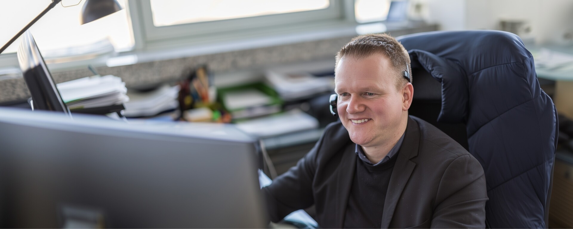 Digitale Lösungen für Reisebüros: Mitarbeiter mit Headset am IT-Service-Arbeitsplatz